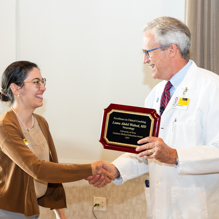 two people shake hands at the GME leadership symposium