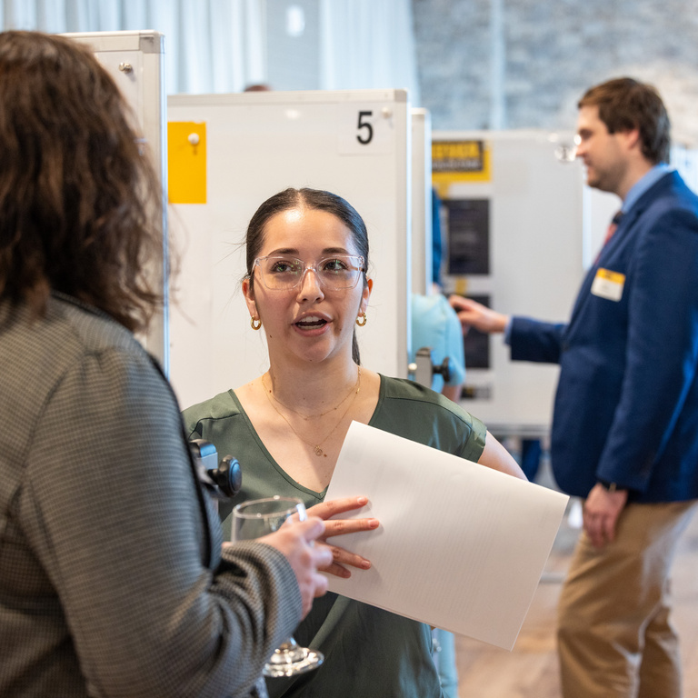 photo of two people talking at educational innovation poster session