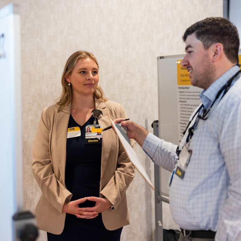 Photo of two doctors speaking at educational innovation poster session
