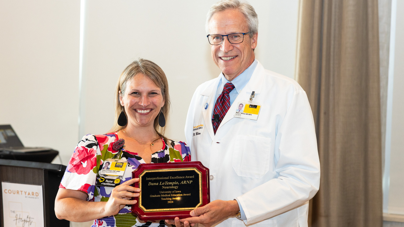 2025 Excellence in Interprofessional Education Winner, Dana LoTempio, ARNP in Epilepsy and Chief Informatics Officer – Neurology, receives her award from Dr. Mark Wilson.